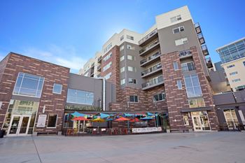 A modern building with a glass facade and a brick facade with a colorful mural on the ground.